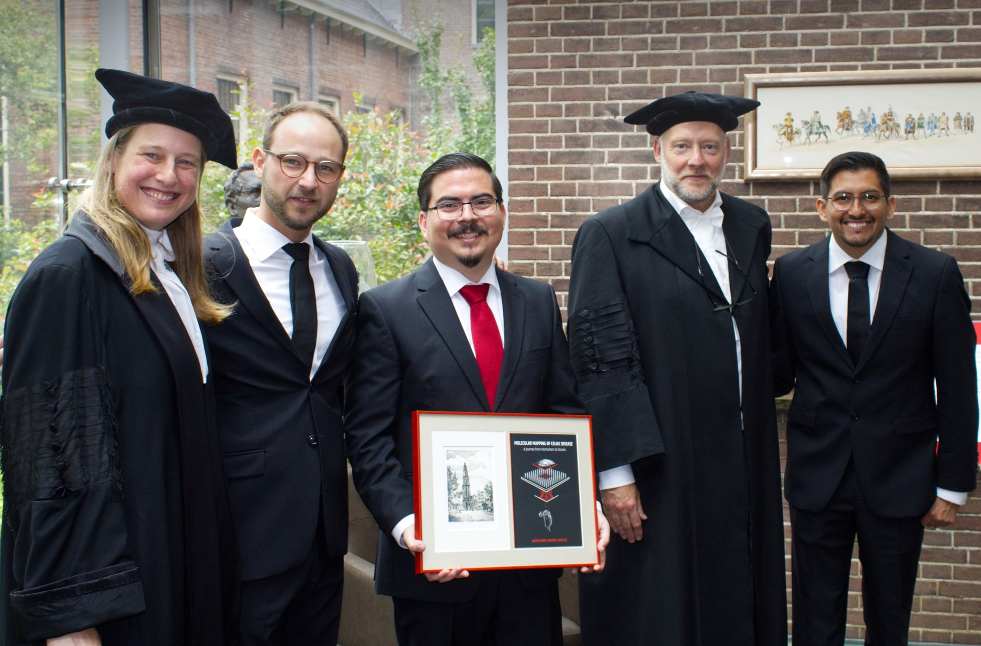 Aarón D. Ramírez Sánchez holding his PhD certificate, standing alongside his supervisors and internationally recognized celiac disease experts.